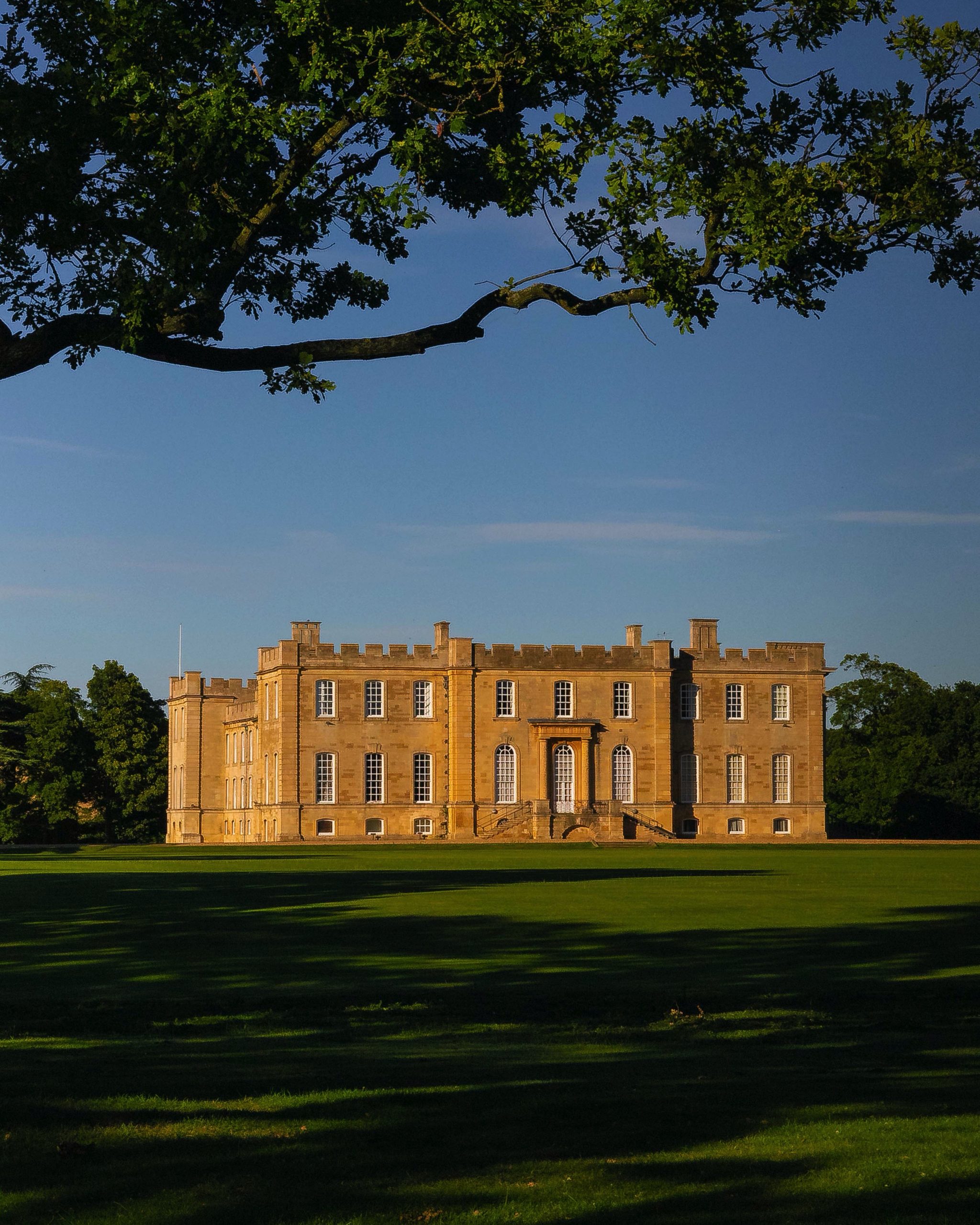Photo of Kimbolton Castle from beneath a tree.